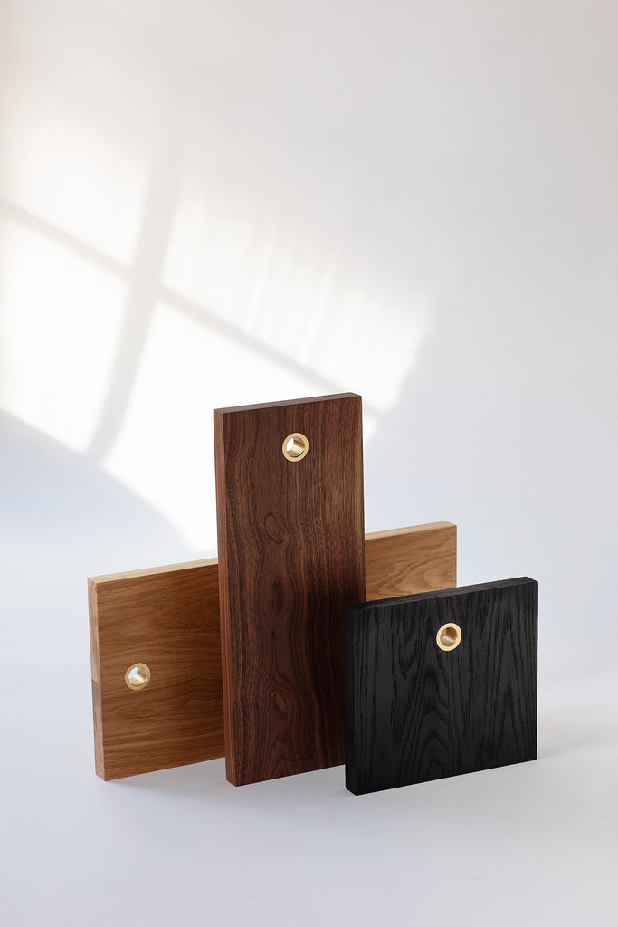 Solid wood serving boards with brass ring. Handmade in Vancouver BC by Brett Yarish. Pictured here are all 3 sizes: No.1 in Blackened Oak, No.2 in Black Walnut and No.3 in White Oak